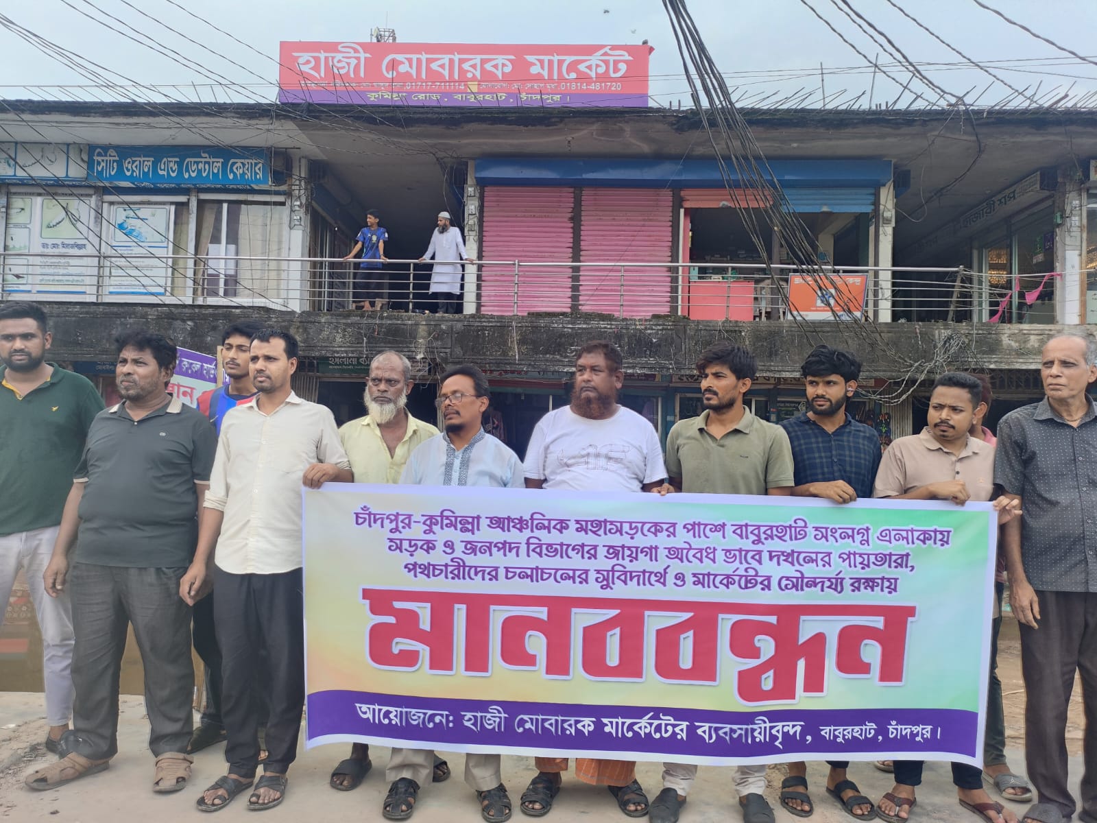 বাবুরহাট হাজী মোবারক মার্কেটের সামনে অবৈধ স্থাপনার নির্মাণ ঠেকাতে ব্যবসায়ীদের মানববন্ধন